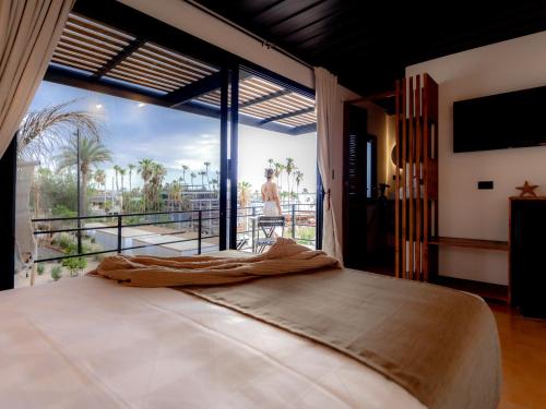 a bedroom with a large bed and a large window at InHouse Glamping Hotel La Paz in La Paz