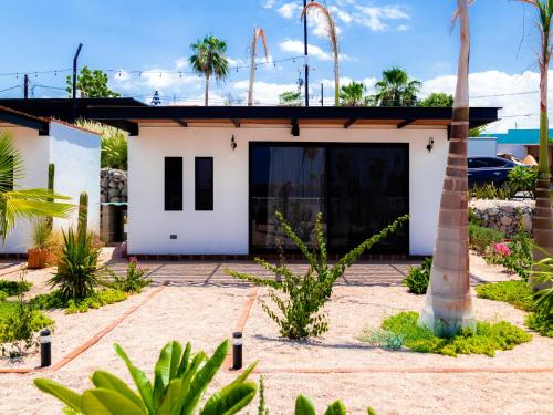 a white house with palm trees in front of it at InHouse Glamping Hotel La Paz in La Paz