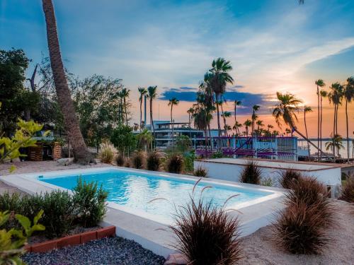 a swimming pool in a resort with palm trees at InHouse Glamping Hotel La Paz in La Paz