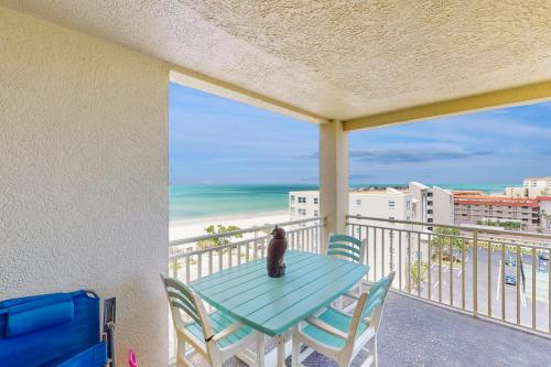 a cat sitting on a table on a balcony with the beach at Anglers Cove 608 in St. Pete Beach