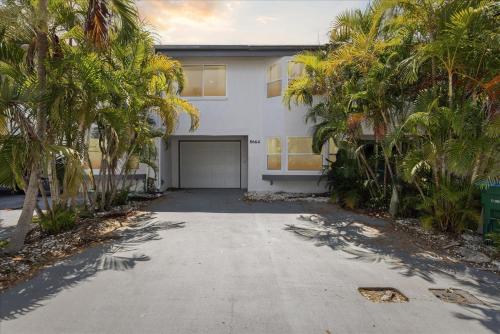 a white house with a garage and palm trees at 8664 N Atlantic Ave in Cape Canaveral
