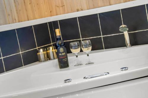 a bottle of wine and two glasses on a bath tub at C11308-Tarm-Stikkelsbaervej-41 in Tarm
