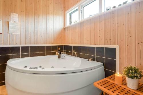 a bathroom with a white tub and a sink at C11308-Tarm-Stikkelsbaervej-41 in Tarm