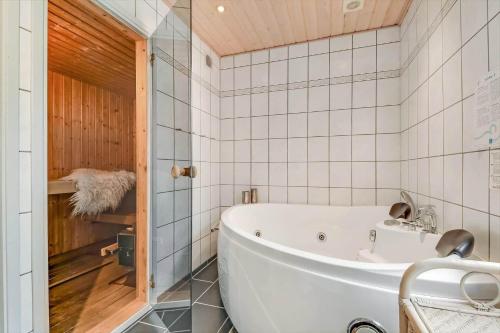 a bath tub in a bathroom with white tiles at C11663-Hemmet-Mosevaenget-9 in Hemmet
