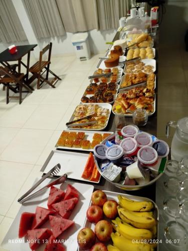 un lungo buffet di cibo su un tavolo di Tradicional Plaza Hotel a Nerópolis