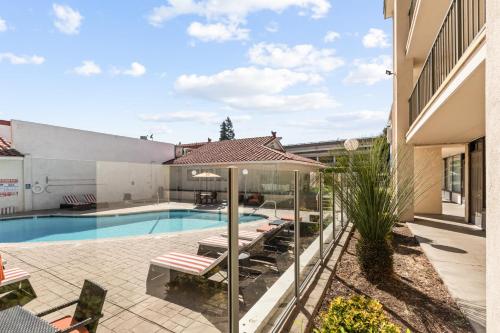 a swimming pool with a patio and a house at Vagabond Inn Executive Old Town in Sacramento