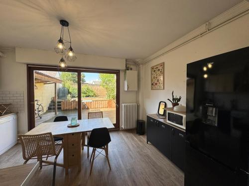 salon ze stołem i dużym oknem w obiekcie Charmante petite maison en plein centre-ville w mieście Mayenne