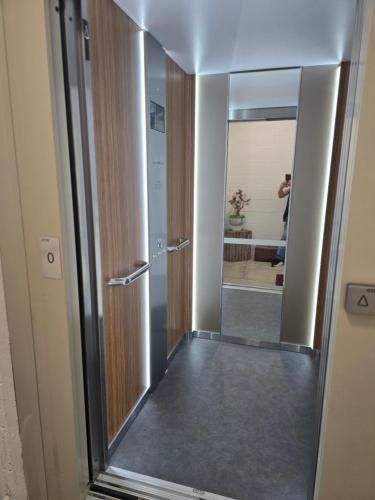 a hallway with a door and a mirror at Appartement cosy proche Sceneo, Auchan, Saint-Omer in Longuenesse