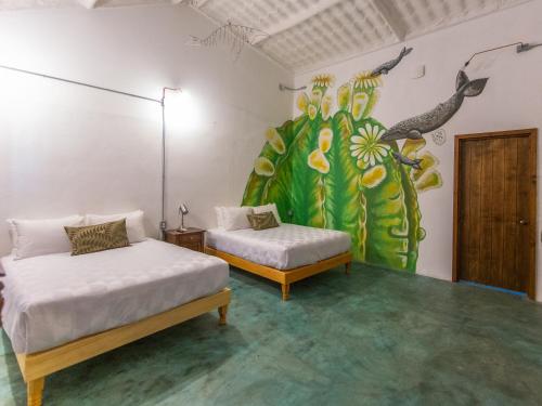 a room with two beds and a mural on the wall at InHouse Glamping Hotel La Paz in La Paz