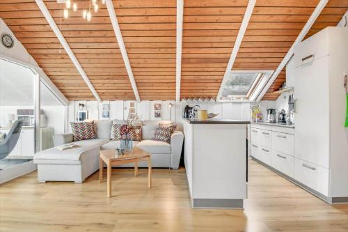 una sala de estar con muebles blancos y techos de madera. en C11402-Skjern-Gyvelvej-74, en Skjern