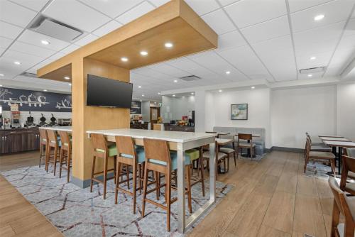 a restaurant with a bar with wooden stools at Best Western Plus Suites Downtown Calgary in Calgary