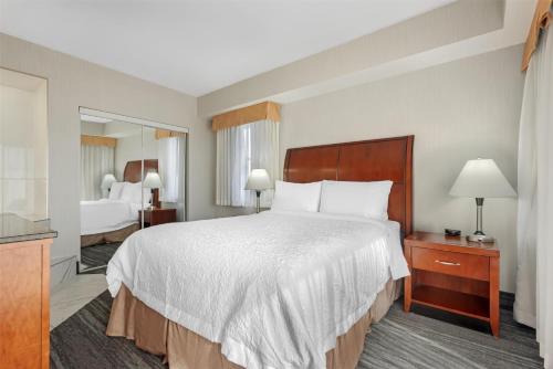 a hotel room with a large bed and a mirror at Best Western Plus Suites Downtown Calgary in Calgary