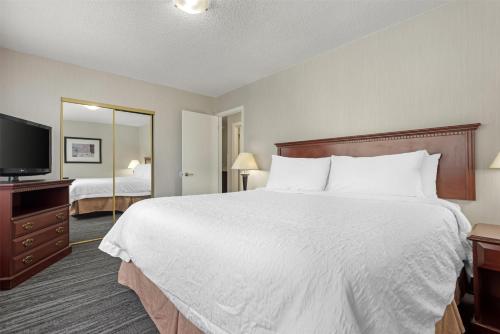 a hotel room with a large bed and a television at Best Western Plus Suites Downtown Calgary in Calgary