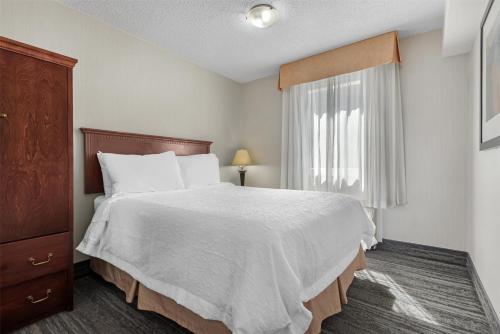a bedroom with a large bed and a window at Best Western Plus Suites Downtown Calgary in Calgary