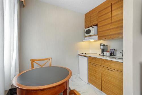 a small kitchen with a table and a microwave at Best Western Plus Suites Downtown Calgary in Calgary