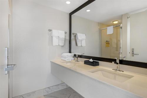 a bathroom with two sinks and a large mirror at Best Western Plus Suites Downtown Calgary in Calgary