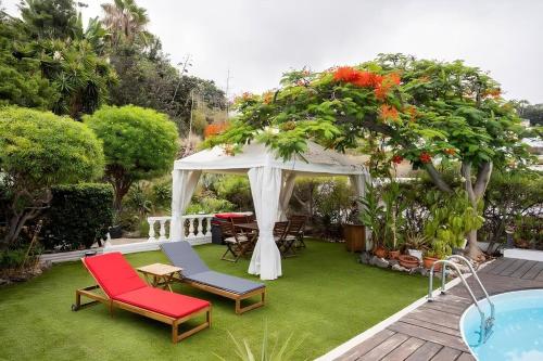 a garden with a gazebo and a pool at Modern Panoramic Villa with Pool & Terrace in Puerto de la Cruz