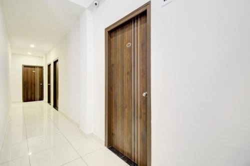a hallway with a wooden door in a building at FabExpress Urban Inn - Yeswanthpur in Bengaluru