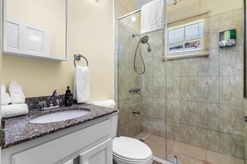 a bathroom with a shower and a toilet and a sink at Cozy Cove Villa in Drax Hall in Saint Annʼs Bay