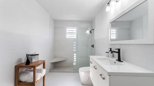 a white bathroom with a sink and a toilet at Apt 413- Walk to the beach, plaza and restaurants in Rincon