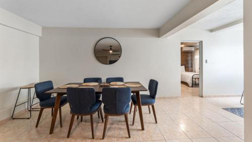 a dining room with a table and blue chairs at Apt 413- Walk to the beach, plaza and restaurants in Rincon
