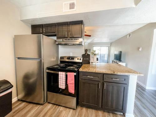 a kitchen with stainless steel appliances and wooden floors at Perfect for Group with 2BR, 2BA and Pool in Robstown