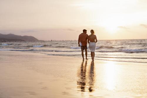 a man and a woman walking on the beach at Norte Suites Boutique in Los Órganos