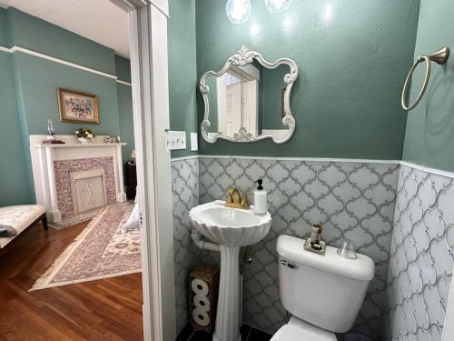 a bathroom with a toilet and a sink and a mirror at The Redbud Room at The Judges Chambers in Guthrie
