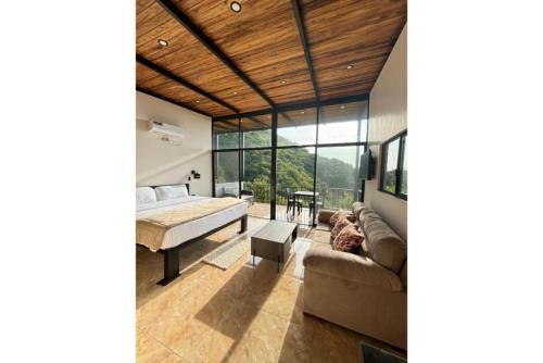 a bedroom with a bed and a couch in a room at Nature Escape Villa with Pools and Jacuzzis and Pet-Friendly Stay in Puerto López