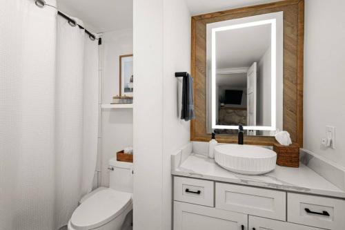a white bathroom with a sink and a mirror at Fully updated condo ski in ski out hot tub pool in Lutsen