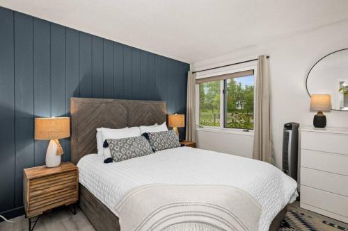 a bedroom with a large bed with a blue wall at Fully updated condo ski in ski out hot tub pool in Lutsen