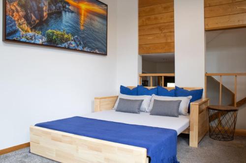 1 dormitorio con 1 cama con sábanas azules y una pintura en la pared en Resort Hot Tub Pool Gym Ski-in out Fire Pits, en Lutsen