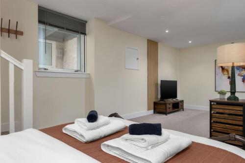 スターリングにあるStirlings Hidden and Tranquil Studio Apartmentのベッドルーム1室(ベッド1台に白いタオル2枚付)