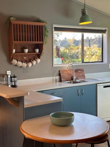 a kitchen with blue cabinets and a bowl on a table at Glacier Barn House in Tatare