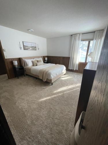 a bedroom with a bed and a large window at Lilac Retreat Lakefront with Sauna & Pickleball in Saint Joseph