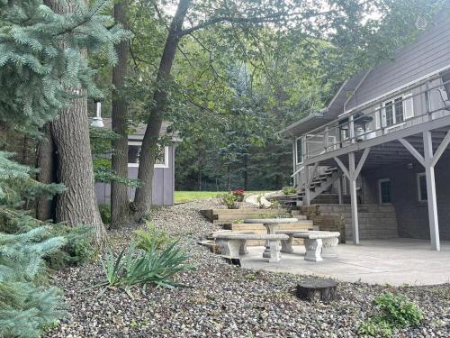 a patio with picnic tables in front of a house at Lilac Retreat Lakefront with Sauna & Pickleball in Saint Joseph