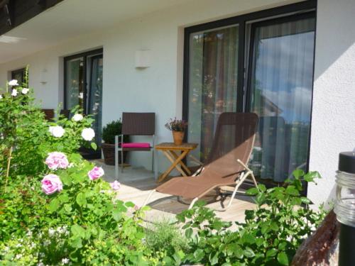a patio with a chair and some flowers at Landhaus Almdorf in Sankt Johann in Tirol