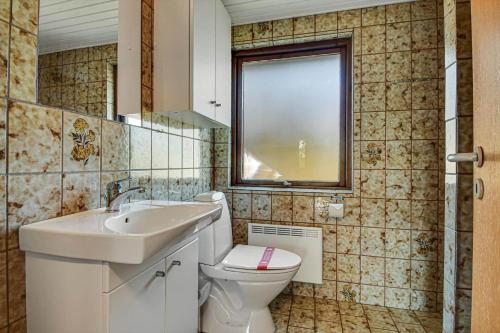 a bathroom with a toilet and a sink and a window at C11603-Norre-Nebel-Marskvej-24 in Nørre Nebel