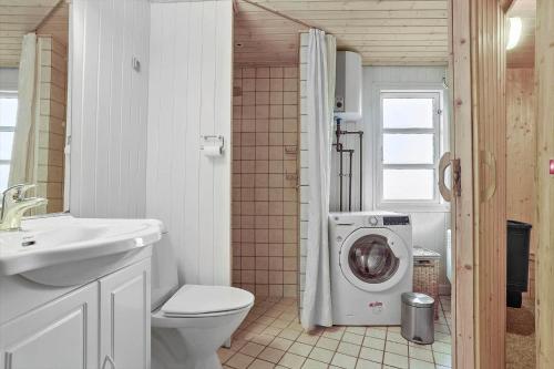 a bathroom with a toilet and a washing machine at SJ243-Haderslev-Vikaerparken-79 in Haderslev