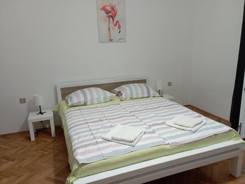 ein Bett mit gestreiften Laken und Kissen in einem Schlafzimmer in der Unterkunft Sole 1 in Novigrad Istria