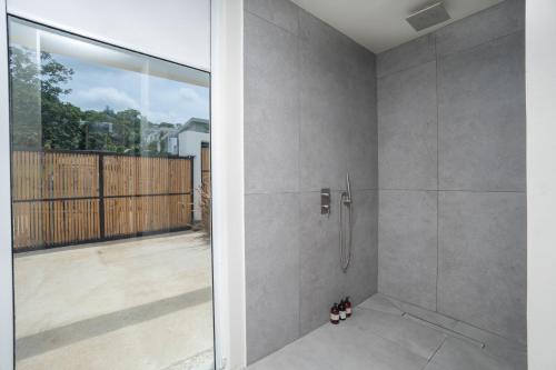 a shower in a bathroom with a glass door at Villa Juba Tamarindo Centro in Tamarindo