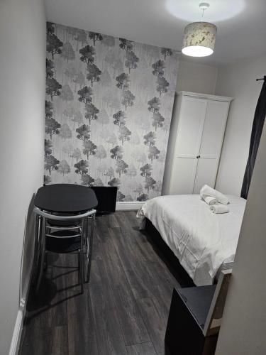a bedroom with a bed and a table and a stool at Ensuite Double Room with Private Kitchen Dudley in Dudley