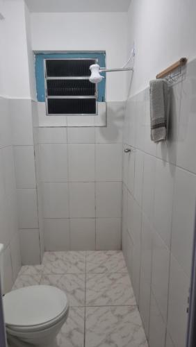 a white bathroom with a toilet and a window at Hotel Parque Mamed in Diadema