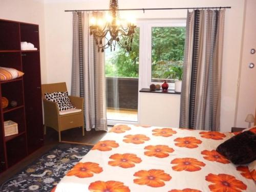 a bedroom with a bed with an orange and white blanket at Landhaus Almdorf in Sankt Johann in Tirol