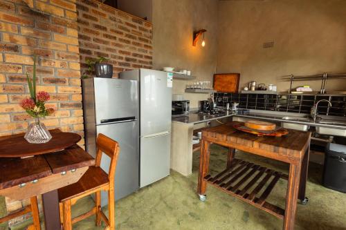 a kitchen with a white refrigerator and a wooden table at Wolfkop Nature Reserve in Citrusdal