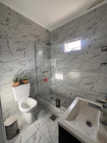 a white bathroom with a toilet and a sink at Excelente propiedad in La Porteña