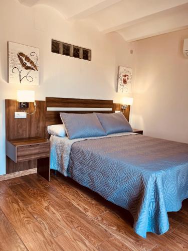 a bedroom with a bed and a wooden floor at Alojamientos Peña del Rey in Cazorla