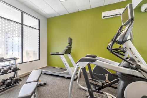 a gym with green walls and tread machines at Spark by Hilton La Crosse Onalaska in Onalaska