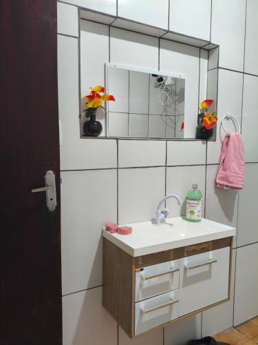 a bathroom with a sink and a mirror at CASA Aconchegante MASSUDA in São Paulo
