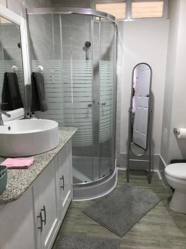 ein Badezimmer mit Dusche, Waschbecken und Toilette in der Unterkunft Amani Grand Resort Residences in Mactan Cebu International